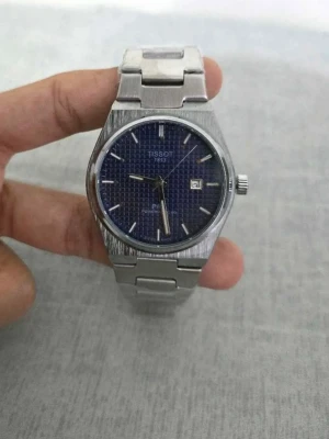 Tissot silverklocka  - Stilren quartz klocka från Tissot i borstat silverfärgat stål med blå urtavla och datumvisning. Länken är i rostfritt stål och har ett snyggt spänne. Perfekt accessoar för dig som gillar klassisk och tidlös design. Helt ny och är inte använd. Box medföljer inte