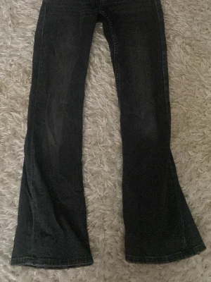 Svarta bootcut jeans Gina Tricot - Snygga svarta bootcut jeans från Gina Tricot i storlek 146. Jeansen har utsvängda ben och klassisk femficksmodell. Tillverkade i ett mjukt denimtyg som ger en bekväm passform och cool look.