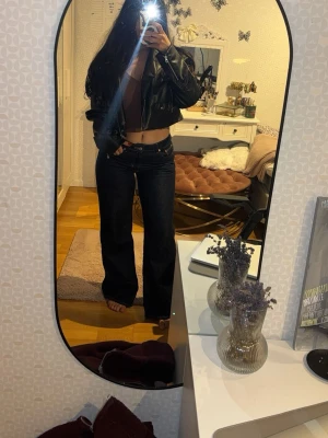 Svart croppad skinnjacka - Säljer en svart croppad skinnjacka med klassisk krage och dragkedja framtill. Jackan har en boxy passform och ger en cool vibe till vilken outfit som helst. Perfekt för dig som vill ha en trendig och edgy look.