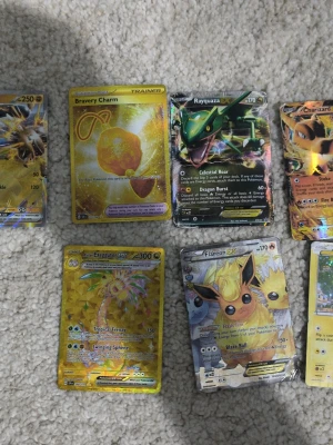 Pokémonkort samling EX och GX - Säljer en samling Pokémonkort med flera EX och GX-kort, bland annat Rayquaza EX, Flareon EX, Charizard EX, Exeggutor GX och Pikachu. Korten har färgstarka illustrationer och holografiska effekter. Perfekt för samlare eller Pokémonfans. Allt är äkta utan rayquaza