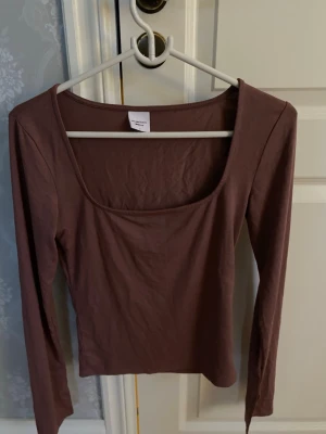 Gammel rosa långärmad topp med en urringning.  - Säljer en gammelrosa långärmad topp från Gina Tricot med snygg  uringning. Även slits på båda ärmarna.  Toppen är i mjuk bomull och har en slim passform som sitter snyggt på kroppen. Perfekt att styla med jeans eller kjol för en trendig look.