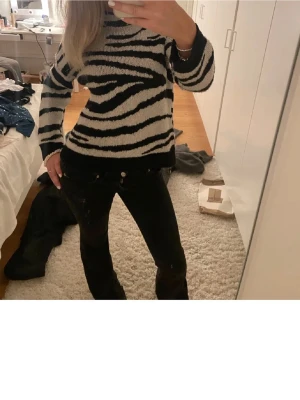 Stickad zebramönstrad tröja - Säljer en stickad tröja med zebramönster i svart och vitt. Tröjan har rund halsringning och långa ärmar. Perfekt för dig som vill sticka ut med en trendig och cool look.