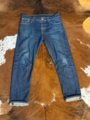 RawDenim NudieJeans SteadyEddie ii DrySelvage greencast straight - Tjena! Säljer dessa helt otvättade Nudie SteadyEddie ii, perfekt för dig som vill bryta in ett par raw selvage jeans, bild 3-4 är bild på ett par steadyeddie i som redan är använda/slitna(dessa är inte till salu utan bara som ett exempel på hur byxorna kan se ut efter hård användning), W36/L32, på bild 5-7 finns måtten, hör av dig vid funderingar!🙌