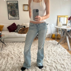 Ljusblå bootcut jeans - Snygga ljusblå bootcut jeans med en klassisk femficksdesign. De har en lågmidjad passform och är perfekta för en avslappnad stil. Jeansen har en lätt tvättad look som ger dem en trendig touch. Inte mina bilder- köpte de här på plick och kommer inte längre till användning 