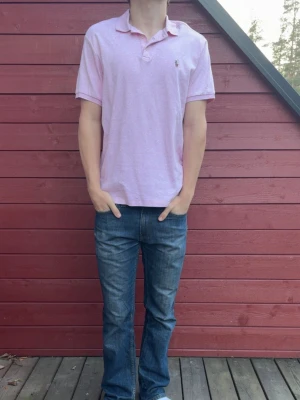 Ralph Lauren piké  - Rosa Ralph Lauren piké i storlek L, piken är i bra skick och är prefekt till sommaren! Tveka inte på att skriva vid frågor eller funderingar. Modellen är ca 180cm lång och väger ca 73kg