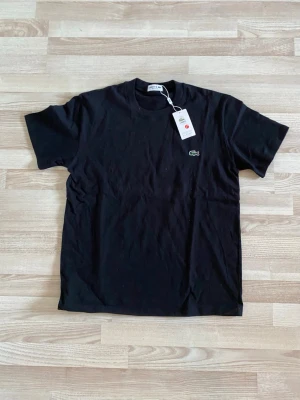 Svart t-shirt från Lacoste - Helt oanvänd. Passar M-L