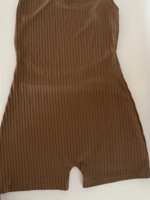 Brown ribbed playsuit  - Brown ribbed playsuit   Size: M Condition: used, in good condition  Details: soft ribbed fabric, stretchy and comfortable, open back, perfect for summer  💰 Price: 90 kr  📦 Fast shipping / meet-up possible Message me if interested 💌