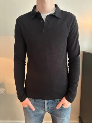 Svart långärmad pikétröja  - Säljer  en svart pikétröja från H&M. Det är en Slim passform och storleken är S. Priset är endast 149kr! Skriv om du har några funderingar om plagget.
