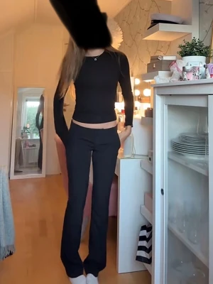Svarta bootcut byxor med låg midja  - Snygga svarta byxor med bootcut-modell och låg midja. Byxorna har en smickrande passform och raka ben som slutar i en lätt utsvängning. Perfekta att styla med crop tops eller stickade tröjor.