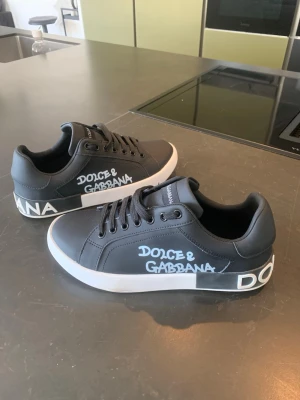 Dolce & Gabbana skor - Tja, säljer nu mina svarta sneakers från Dolce & Gabbana med vit logga på sidan och hälen. Tyvärr passade dom inte och är därmed till salu. Dem är i princip helt nya och är i extremt bra skick. Ett par unika och schyssta skor överlag, perfekta inför denna säsong. Tveka ej att höra av dig vid intresse!😁