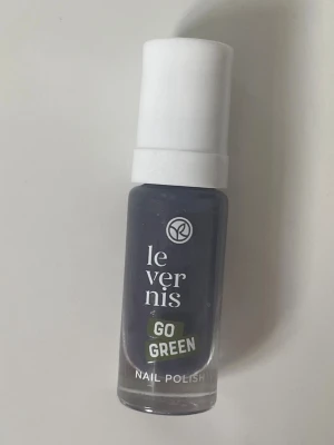 Mörkgrå nagellack Yves Rocher - Snyggt mörkgrått nagellack från Yves Rocher, Le Vernis Go Green-serien. Kommer i en smidig glasflaska med vit kork. Vegansk formula med naturliga ingredienser för dig som vill ha ett trendigt och miljövänligt nagellack.