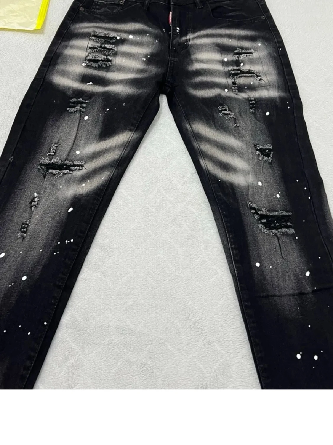 Svarta slitna jeans med färgstänk