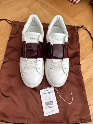 Valentino open - Riktigt fräscha opens i storlek 45, mycket fint skick och i en väldigt sällsynt colourway. De är vinröda/röda med glans. De är som man ser på bilderna knappt använda men de är lagade på ett ställe uppe vid hälen vilket framgår på bilderna. En matchande dustbag medföljer. Skorna är självfallet äkta och de är äkthetsverifierade av Vestiaire collective. Bara att höra av sig vid intresse!