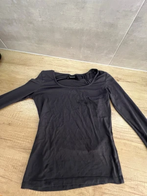 Svart långärmad topp Gina Tricot - En svart långärmad topp från Gina Tricot med rund halsringning. Toppen är figurnära och tillverkad i ett mjukt och stretchigt material som känns skönt mot huden. Perfekt att styla med jeans eller kjol för en enkel och snygg look.
