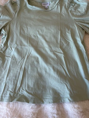 Ljusgrön topp från Aware - Superfin ljusgrön topp från Aware med kort puffärm och rund halsringning. Tillverkad i mjuk bomull som känns skön mot huden. Perfekt att styla med jeans eller kjol för en fräsch look. Skriv för frågor❤️