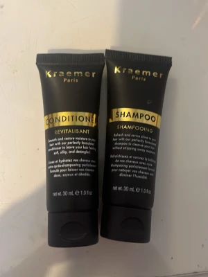 Kraemer Paris schampo & balsam 30ml - Set med schampo och balsam från Kraemer Paris i svarta tuber med gulddetaljer. Varje tub innehåller 30 ml och är perfekt för resan. Schampot rengör och återfuktar håret medan balsamet gör det mjukt och lätt att reda ut. Smidig storlek att ta med i väskan.