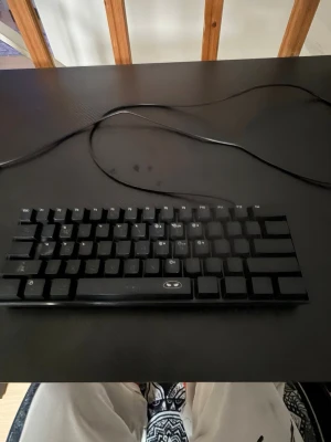Svart kompakt tangentbord med sladd - Säljer ett svart kompakt tangentbord med USB-sladd. Tangentbordet har minimalistisk design utan numerisk del och svarta tangenter med vita tecken. Perfekt för dig som vill ha mer plats på skrivbordet och gillar enkel stil.