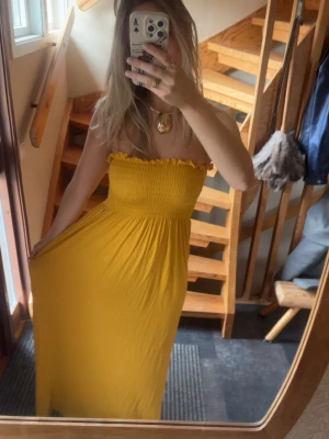 Gul axelbandslös maxiklänning - Solgul axelbandslös maxiklänning i otroligt stretchigt och flowy material. Från Nelly i storlek S och 95% viskos🌻