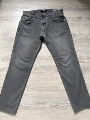Grå jeans från Replay - Ett par riktigt goa replay jeans i grå färg, i storlek  W33 L30. Byxorna är i väldigt fint skick utan defekter. Vid fundering är det bara att hojta till !
