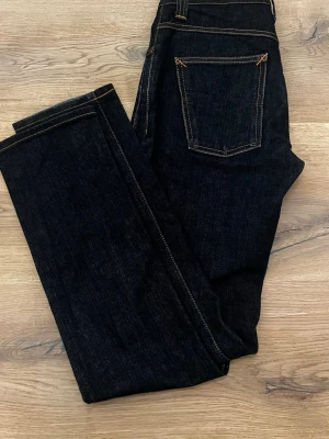 Nudie Grim Tim Dry Navy 30/34 - Säljer nu dessa Nudie jeans, modellen är Grim Tim & sitter slimfit, storleken på dessa är W30 & L34, Färgen är Organic Dry Navy, så vid långvarig användning kommer sköna fades och slitningar automatiskt! nypris på dessa jeansen ligger på 1600, jag har de ute för 799kr men pris går att diskutera, vid frågor är det bara att höra av sig🙌