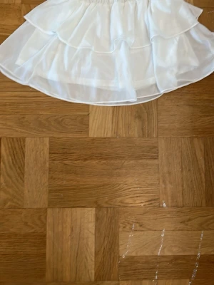 Vit volangkjol från Chelsea  - Söt vit kortkjol från Chelsea med dubbla volanger och resår i midjan. 