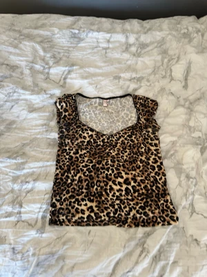 Leopardmönstrad v-ringad topp - Snygg topp med leopardmönster och v-ringning. Kortärmad modell i mjukt material som sitter bekvämt och har en trendig look. Perfekt för dig som vill sticka ut lite extra.