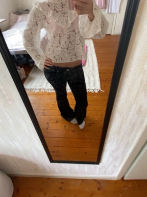 Vit spetsblus med volangdetalj - Spetsblus från Nelly storlek M skulle säga att den kanske är xs/s. Har en liten gul fläck som knappast märks