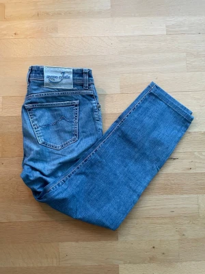 Jacob Cohën Straight Fit Jeans - Jacob Cohën straight fit jeans i blå. Mycket bra skick, använda ett fåtal gånger och har ett mycket bra helhetsintryck. Mått: 40 cm midja, 95 cm längd. Material: 100% bomull. Säljes som de är. Skickas välpackade inom 24 timmar.