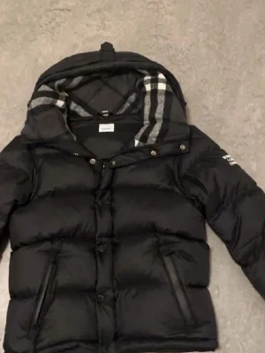 Burberry jacka - Tjenare ! Jag gör mig av med min Burberry-jacka eftersom den inte riktigt passar in i min garderob längre. Den är i toppskick, nästan oanvänd och helt felfri. Jag köpte den online och den är givetvis äkta. En smart detalj är att man kan ta av ärmarna och använda den som väst. Perfekt för både höstkyliga dagar och som varmt lager under vintern. Fråga på om det är något du undrar! 👍