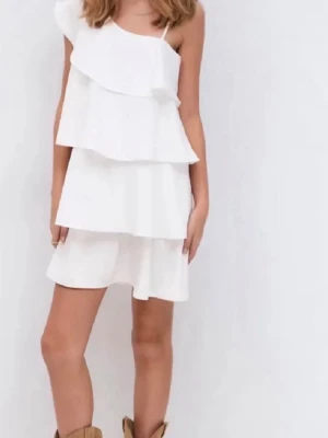 Vit klänning med volanger - Säljer en vit kortklänning med volangdetaljer. Klänningen har en axelbandslös design på ena sidan och ett smalt axelband på andra sidan, vilket ger en asymmetrisk look. Perfekt för sommarens alla tillfällen! Gina Young 164 men passar som xs 