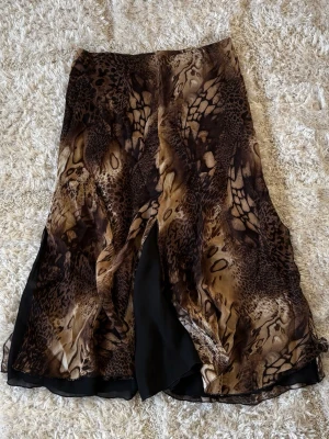 Brun långkjol med leopardmönster - Säljer en flowy långkjol med leopardmönster i olika bruna toner. Ett snyggt och väldigt unikt plagg!