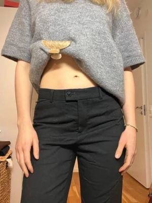 Mörkgråa Kostymbyxor I Ull - Gråa kostymbyxor från Atelier Gardeur med knapp och dragkedja framtill. Modellen är rak och midwaist/ låg. Byxorna är i perfekt skick förutom den lilla detaljen att dragkedjan inte sitter fast, går säkert att fixa superenkelt men jag orkar inte. Storlek 38 men passar även 36. Är 170 och på mig är de lagomt långa.  Innerbenslängd: 79 Midjemått: 38cm