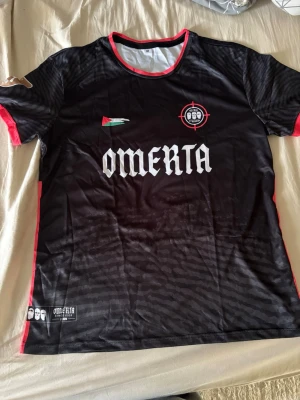 Svart Omerta sporttröja - Snygg svart sporttröja från Omerta med röda detaljer finns många storlekar