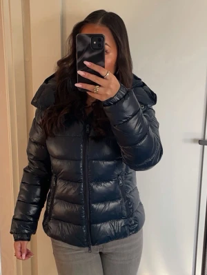 Mörkblå pufferjacka med huva - Mörkblå pufferjacka från lager 157 i storlek S. 