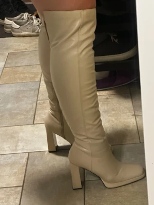 Långa Beige boots  - Storlek 40, passar för breda fötter. Lite skador men man kan knappt se det!
