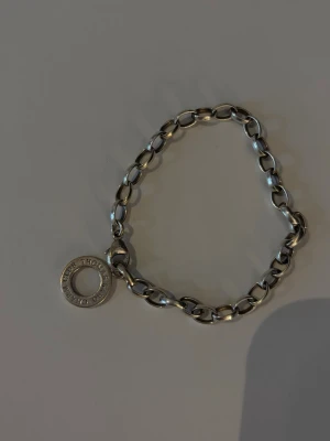 Silverfärgat armband från Efva Attling - Snyggt armband i silverfärgad metall från Thomas Sabo med grova länkar och en rund berlock där det står Thomas Sabo''. Perfekt för dig som gillar stilrena och moderna smycken med en unik touch. Länkarna ger ett coolt och trendigt intryck. Det går även att köpa små berlocker som tillhör att sätta på💕