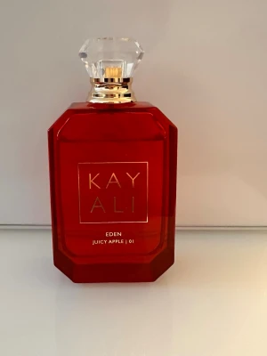 Kayali Eden Juicy Apple parfym - Kayali Eden Juicy Apple 01 är en parfym i en snygg, röd, geometrisk glasflaska med guldiga detaljer och en kristalliknande transparent kork. Doften är fruktig och modern, perfekt för dig som gillar fräscha och söta toner. Ordinarie pris 1429kr.