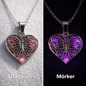 Halsband med hjärthänge och fjäril som lyser i mörker  - Unikt halsband med ett hjärtformat hänge i silverfärgad metall. Hänget har ett detaljerat fjärilsmotiv och byter färg från rosa i dagsljus till lila i mörker. Vanligt dagsljus aktiverar effekten i hänget och det börjar därför att lysa/ge ett lila sken i mörker som kan vara i flera timmar. Perfekt statement-piece för dig som gillar smycken med coola effekter och snygg design. Kedjan är 45 cm + 5 cm förlängningskedja i rostfritt stål. Handgjort halsband. 