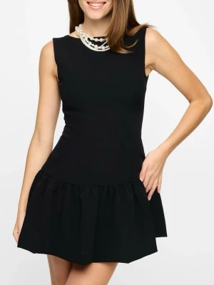 Svart kort klänning med prislapp kvar - Helt ny Stilren svart kort klänning med rund halsringning och öppen rygg. Klänningen har en volangkant nedtill och är ärmlös, vilket ger en modern och ungdomlig look. Prislappen sitter kvar och har endast används en gång.🥰