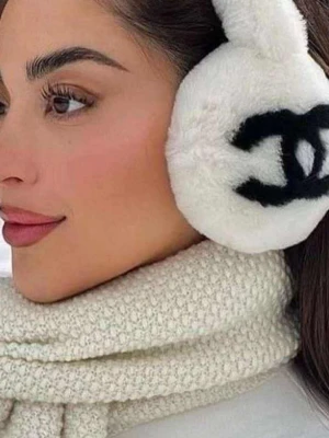 Vita fluffiga öronmuffar från Chanel - Superfina vita öronmuffar från Chanel med svart logga på sidorna. De är gjorda i mjukt, fluffigt material som håller dig varm och ger en lyxig känsla. Perfekt accessoar för kalla dagar och en snygg detalj till vinterlooken.