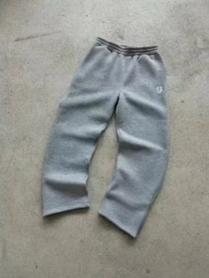 Helt nya Y2K byxor  - Säljer ett par Y2K byxor med avslappnad passform och resår i midjan. Byxorna har en liten vit broderad logga på vänster höft. Perfekta för chill dagar och riktigt sköna att ha på sig.