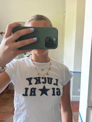 Tshirt från Subdued - Vit t-shirt med mörkblå texten 'LUCKY GIRL' och en stjärna på bröstet. Klassisk rund hals och korta ärmar. Perfekt för en avslappnad och trendig look. Står M men italenska storlekar så passar XS