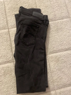 Svarta slim fit jeans från Replay - Säljer ett par svarta slim fit jeans från Replay. Jeansen har klassisk femficksdesign, normal midja och är tillverkade i ett mjukt denimtyg med lite stretch för extra komfort. Snygga och stilrena, perfekta till många olika looks.