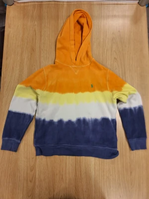 Polo Ralph Lauren för barn/ungdom - Säljer en Polo Ralph Lauren hoodie för barn i tie dye färg som är väldigt populär. Mjuk bomullskvalitet och avslappnad passform. Väldigt fin hoodie och hög kvalité. Det är ingen ny hoodie och spår av användning finns, därav det låga priset, men defekterna påverkar inte överlag helhetsintryck av hoodien och är väl dolda. Perfekt som en julklapp eller födelsedagspresent till de mindre (ålder ca. 8-13 år). 