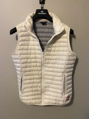 Vit dunväst från colmar - Snygg vit dunväst från Parajumpers med quiltad design och hög krage. Västen har två dragkedjeförsedda fickor fram och en diskret logga vid nederkanten. Perfekt att slänga över en hoodie eller tröja för extra värme. Clean vest från filmar storlek S sitter tajt och bra riktigt snygg med en hoodie under 