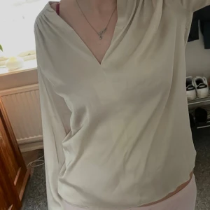 Champagnefärgad Satinblus - Satinliknande material. Storlek S. Knappt använd