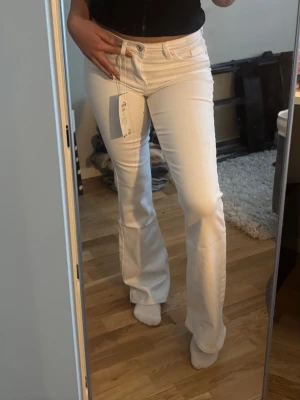 Vita bootcut jeans  - Snygga vita midweist bootcut jeans från Only med en klassisk femficksdesign, som tyvärr aldrig kommit till användning och förtjänar en ny garderob. Jeansen har en figurnära passform upptill och utsvängda ben. Perfekta för dig som vill ha en fräsch och trendig look. Materialet är stretchigt för extra komfort.