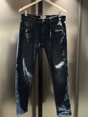 Mörkblå jeans från Replay - PRISTER KAN DISKUTERAS!!Helt nya, aldrig använda!   Snygga mörkblå jeans från Replay med klassisk femficksdesign och kontrastsömmar. Jeansen har en smal passform och läderpatch med logga bak i midjan. Perfekta för en trendig och avslappnad look.