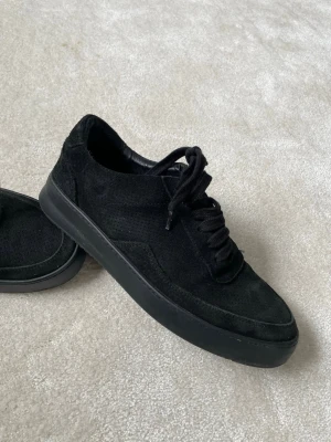 Filling Pieces svarta mockasneakers - Stilrena svarta sneakers i mocka med lågt skaft och svarta skosnören. Yttermaterialet är mjukt mockaläder och sulan är i svart gummi. Perfekta för dig som gillar en clean och minimalistisk look.