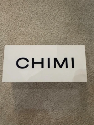 Bruna solglasögon från CHIMI - Snygga solglasögon från CHIMI med transparent brun ram och rektangulär form. Kommer i originalfodral med logga. Perfekta för dig som vill ha en stilren accessoar med modern touch.